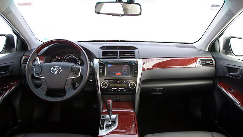 Interior luxuoso tem acabamento em madeira | <a href="https://preprod.quatrorodas.abril.com.br/carros/lancamentos/toyota-camry-2013-679638.shtml" rel="migration">Leia mais</a>