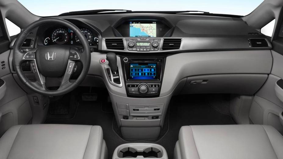 Por dentro, o console central foi renovado. Outros detalhes revistos foram o botão de acionamento do motor, central multimídia HondaLink (com integrações com smartphones)... | <a href="%20https://preprod.quatrorodas.abril.com.br/saloes/new-york/2013/honda-odyssey-73" rel="migration"></a>