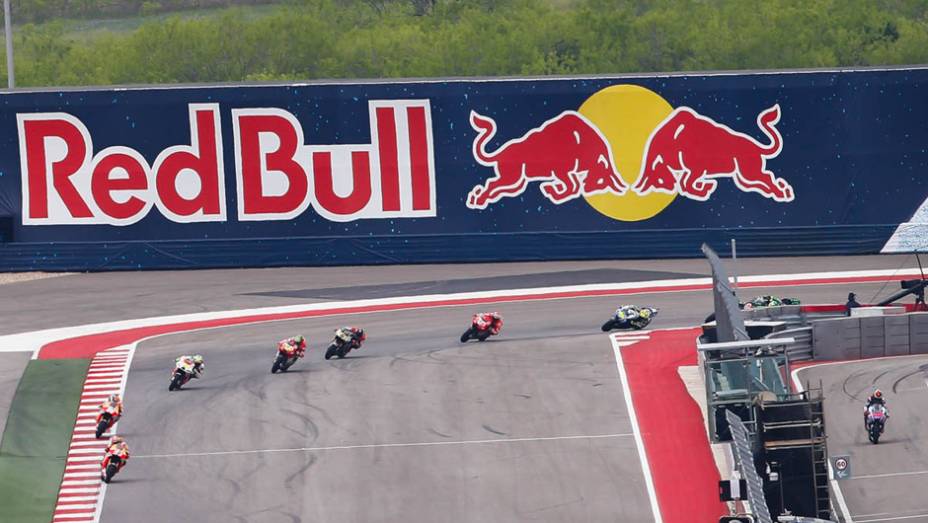 Pilotos entrando na reta para completar a primeira volta. | <a href="https://preprod.quatrorodas.abril.com.br/moto/noticias/marquez-passeia-vence-gp-austin-motogp-779654.shtml" rel="migration">Leia mais</a>