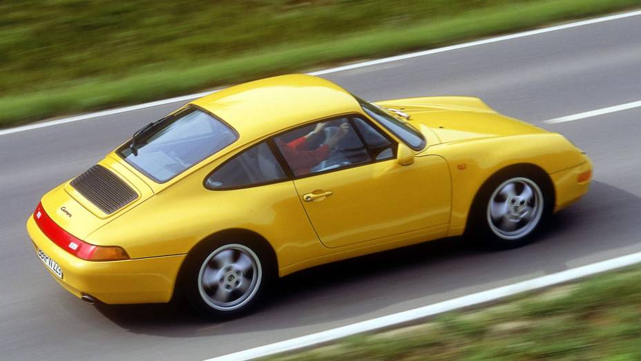 911 Carrera 1994 (993) - Os para-choques foram camuflados como parte da carroceria, tornando o desenho mais leve e moderno | <a href="%20https://preprod.quatrorodas.abril.com.br/reportagens/classicos/porsche-911-50-anos-748361.shtml" rel="migration">Leia mais</a>