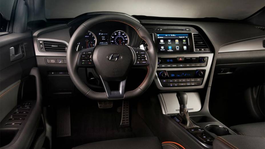 Seu interior é um pouco simples, mas vem muito bem equipado com ar condicionado e assentos de estofado premium | <a href="https://preprod.quatrorodas.abril.com.br/noticias/saloes/new-york-2014/hyundai-revela-sonata-2015-nova-york-779988.shtml" rel="migration">Leia mais</a>