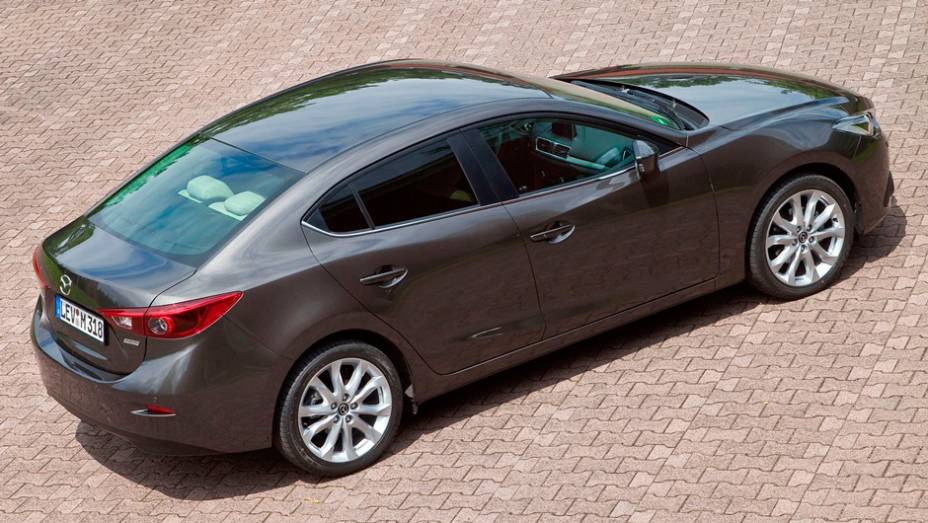 Novo Mazda3 Sedan parece um Mazda6 compacto, com um teto alongado e uma nova traseira mais atraente | <a href="https://preprod.quatrorodas.abril.com.br/noticias/fabricantes/primeiras-fotos-oficiais-mazda3-sedan-2014-sao-reveladas-745927.shtml" rel="migration">Leia mais</a>