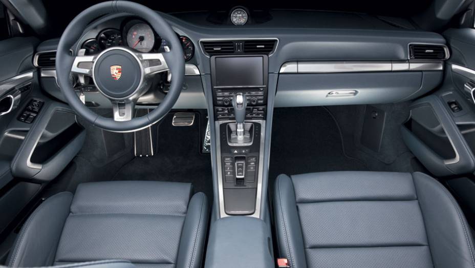 Tela de 7 polegadas sensível ao toque no console elevado mantém comandos à mão | <a href="https://preprod.quatrorodas.abril.com.br/carros/lancamentos/porsche-911-carrera-s-687122.shtml" rel="migration">Leia mais</a>