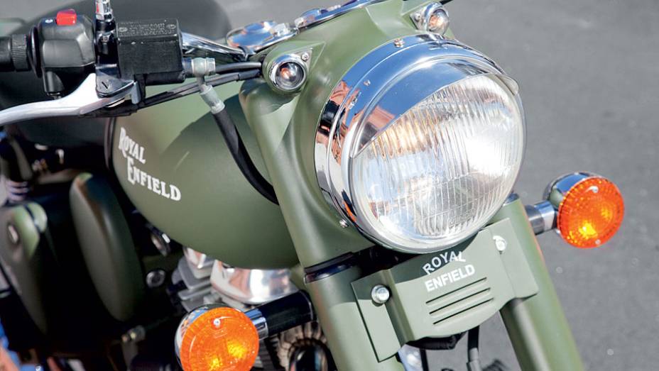 Grade retilínea sob farol com pestana destoa | <a href="https://preprod.quatrorodas.abril.com.br/moto/testes/royal-enfield-classic-500-military-green-705420.shtml" rel="migration">Leia mais</a>