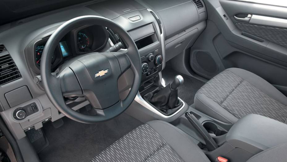 Versão LS básica vem com bancos de tecido, ar-condicionado e freios ABS. | <a href="https://preprod.quatrorodas.abril.com.br/carros/testes/chevrolet-s10-681120.shtml" rel="migration">Leia mais</a>