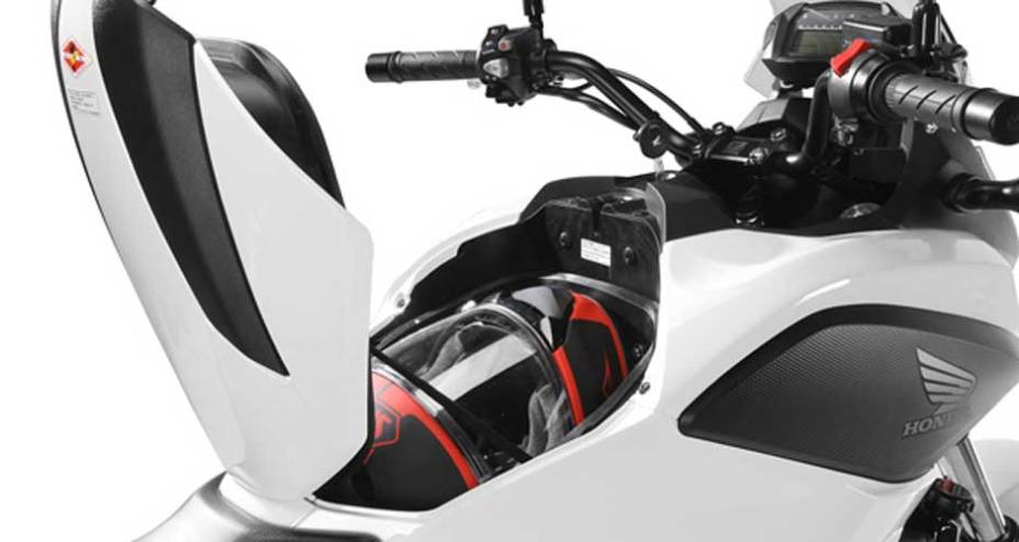 Localizado onde normalmente fica o tanque de combustível, o porta-objetos é ideal para guardar capacete e outros pertences | <a href="https://preprod.quatrorodas.abril.com.br/moto/noticias/honda-nc-700x-made-in-manaus-691787.shtml" rel="migration">Leia mais</a>