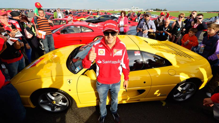 Piloto da Ferrari posou para fotos com os modelos | <a href="https://preprod.quatrorodas.abril.com.br/noticias/fabricantes/ferrari-consegue-reunir-964-modelos-marca-silverstone-702287.shtml" rel="migration">Leia mais</a>