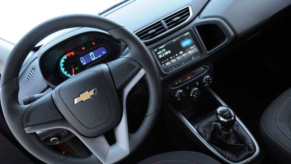 O painel traz várias peças em comum com outros carros da GM, como o volante vindo do sedã Cruze | <a href="%20https://preprod.quatrorodas.abril.com.br/salao-do-automovel/2012/carros/onix-708485.shtml" rel="migration">Leia mais</a>