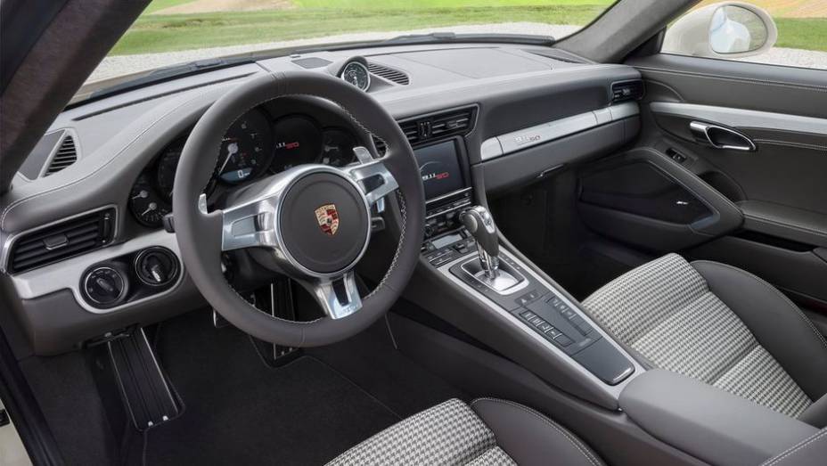 Entre as novidades visuais, estão insígnias da edição especial em alguns pontos do carro, detalhes em verde no painel de instrumentos, entre outras | <a href="https://preprod.quatrorodas.abril.com.br/saloes/frankfurt/2013/porsche-911-50th-anniversary-edition-75323" rel="migration"></a>