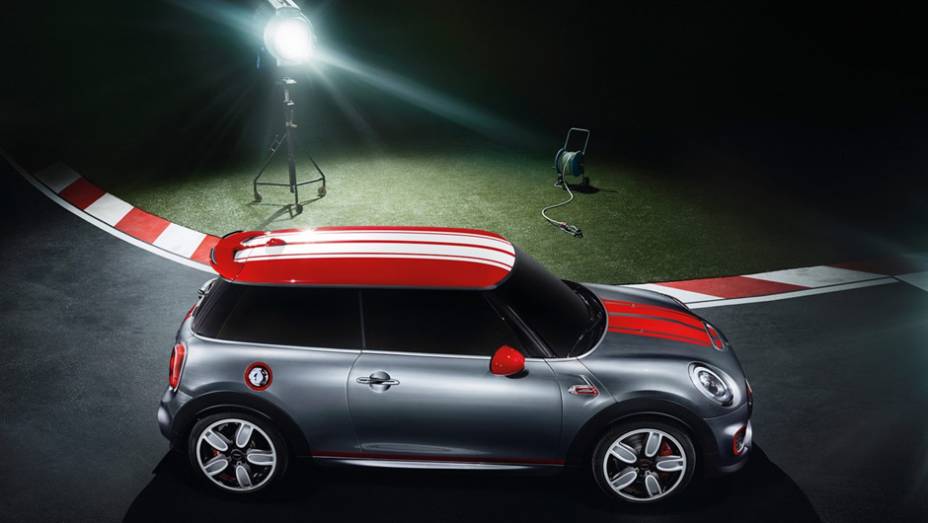 O carro-conceito tem cor de carroceria cinza, com faixas vermelhas no capô, teto com base vermelha e faixas brancas e outras inserções vermelhas na carroceria | <a href="https://preprod.quatrorodas.abril.com.br/noticias/saloes/detroit-2014/mini-mostra-novo-jcw-con" rel="migration"></a>