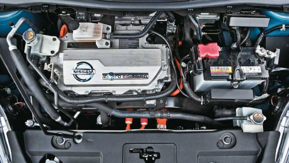 No topo do motor elétrico, a capa do inversor de potência imita uma tampa de cabeçote. Mesmo depois de rodar muito com o Leaf, não há calor no cofre do motor | <a href="https://preprod.quatrorodas.abril.com.br/salao-do-automovel/2012/carros/leaf-703954.shtml" rel="migration">Leia</a>