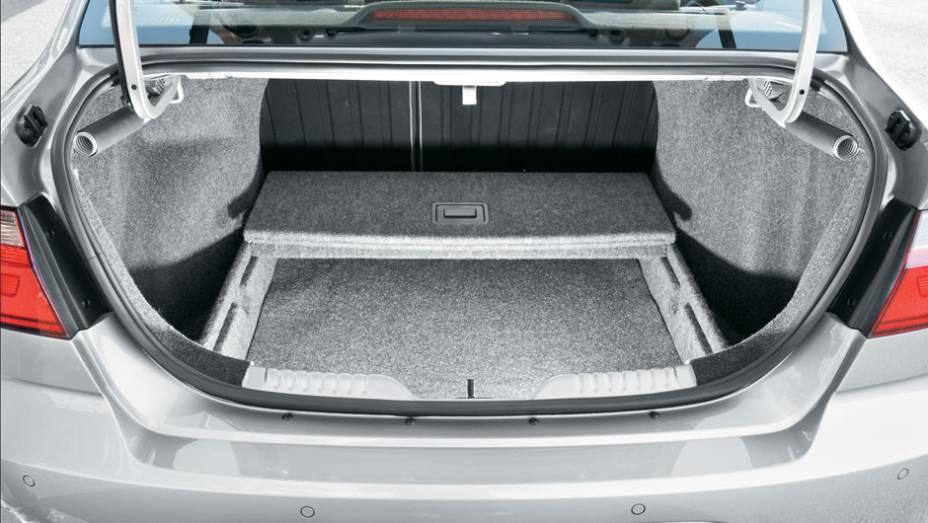 Caixa opcional cria fundo falso no porta-malas | <a href="https://preprod.quatrorodas.abril.com.br/carros/lancamentos/vw-voyage-comfortline-699016.shtml" rel="migration">Leia mais</a>