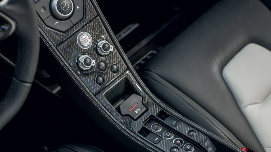 Console reúne os comandos que ajustam o carro ao estilo do piloto | <a href="https://preprod.quatrorodas.abril.com.br/carros/impressoes/mclaren-mp4-12c-spider-736652.shtml" rel="migration">Leia mais</a>