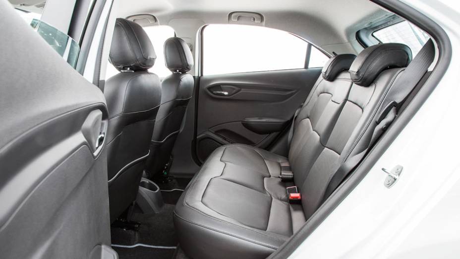 Atrás, o espaço é aceitável para dois adultos, mas falta encosto no meio | <a href="https://preprod.quatrorodas.abril.com.br/carros/testes/chevrolet-onix-725300.shtml" rel="migration">Leia mais</a>