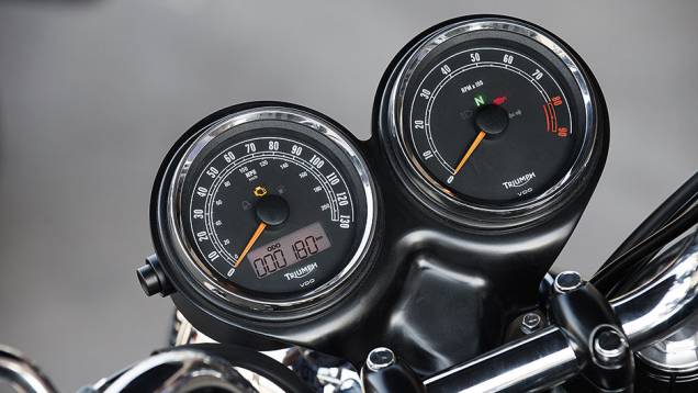 Painel com 2 visores redondos e pequeno LCD | <a href="https://preprod.quatrorodas.abril.com.br/moto/testes/triumph-bonneville-t100-741213.shtml" rel="migration">Leia mais</a> Painel com 2 visores redondos e pequeno LCD | <a href="https://preprod.quatrorodas.abril.com.br/moto/testes/triumph-bonneville-t100-741213.shtml" rel="migration">Leia mais</a>