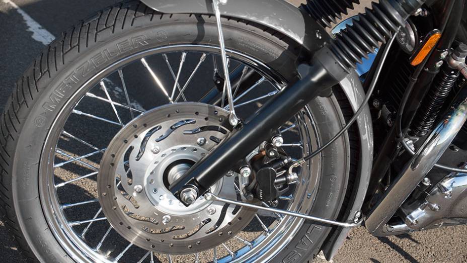 Bons pneus, um disco frontal e rodas raiadas na versão T100 | <a href="https://preprod.quatrorodas.abril.com.br/moto/testes/triumph-bonneville-t100-741213.shtml" rel="migration">Leia mais</a>