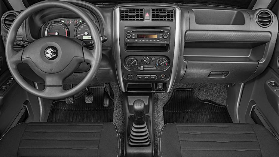Painel tem simplicidade de carro b&aacute;sico e acabamento idem. Luxo n&atilde;o &eacute; seu forte | <a href="https://preprod.quatrorodas.abril.com.br/carros/testes/suzuki-jimny-737775.shtml" rel="migration">Leia mais</a>