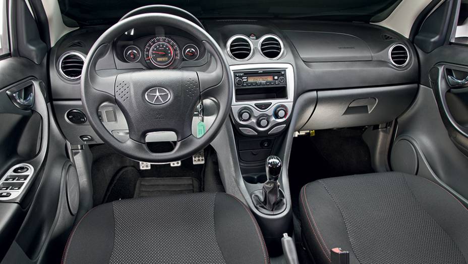 Volante de quatro raios e sa&iacute;das de ventila&ccedil;&atilde;o t&ecirc;m detalhes cromados | <a href="https://preprod.quatrorodas.abril.com.br/carros/comparativos/jac-j3-1-5-s-x-chery-celer-1-5-744920.shtml" rel="migration">Leia mais</a>