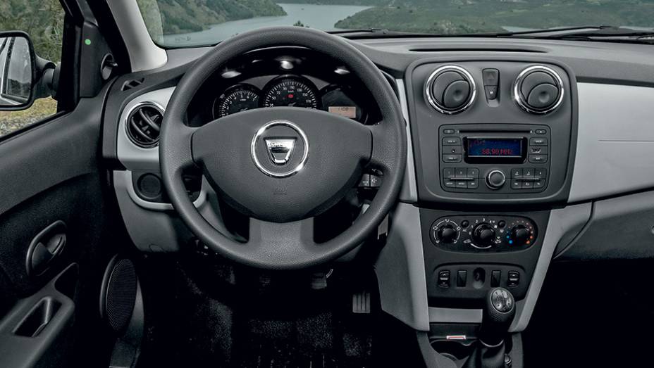 Interior farto em acabamento de plásticos duros, inclusive no volante | <a href="https://preprod.quatrorodas.abril.com.br/carros/impressoes/dacia-logan-749339.shtml" rel="migration">Leia mais</a>