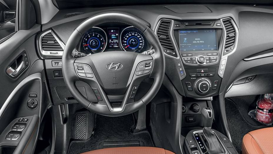 Interior caprichado é repleto de comandos. Há até um certo exagero de informações | <a href="https://preprod.quatrorodas.abril.com.br/carros/impressoes/hyundai-santa-fe-7-lugares-759289.shtml" rel="migration">Leia mais</a>