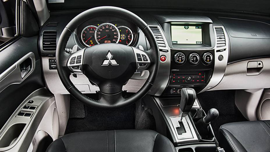Bancos de couro e console central com acabamento que imita tit&acirc;nio | <a href="https://preprod.quatrorodas.abril.com.br/carros/testes/mitsubishi-pajero-dakar-hpe-765655.shtml" rel="migration">Leia mais</a>