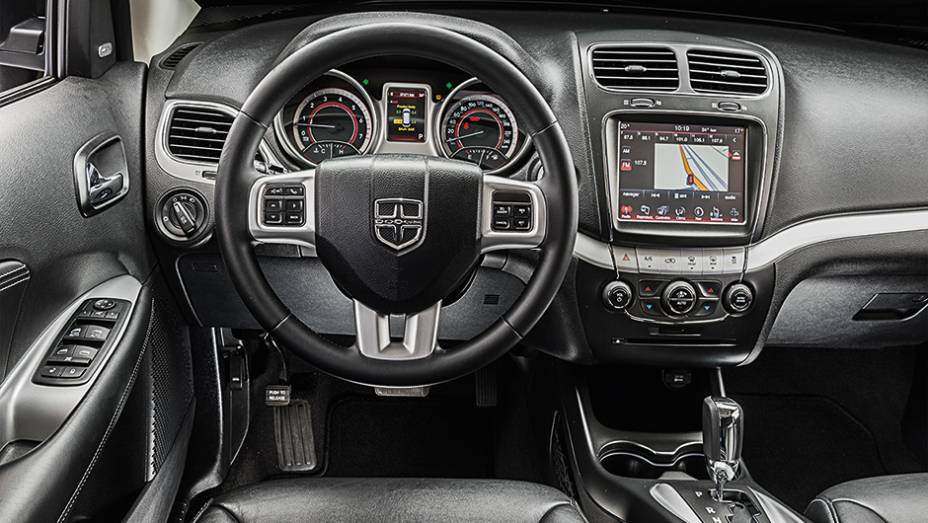 O volante multifuncional leva o emblema da Dodge (no lugar do da Fiat) | <a href="https://preprod.quatrorodas.abril.com.br/carros/comparativos/dossie-sete-lugares-120-mil-reais-772708.shtml" rel="migration">Leia mais</a>