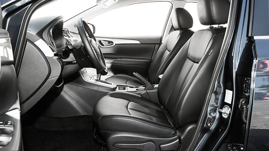 Interior do Nissan tem cores escuras | <a href="https://preprod.quatrorodas.abril.com.br/carros/comparativos/sedas-medios-783295.shtml" rel="migration">Leia mais</a>