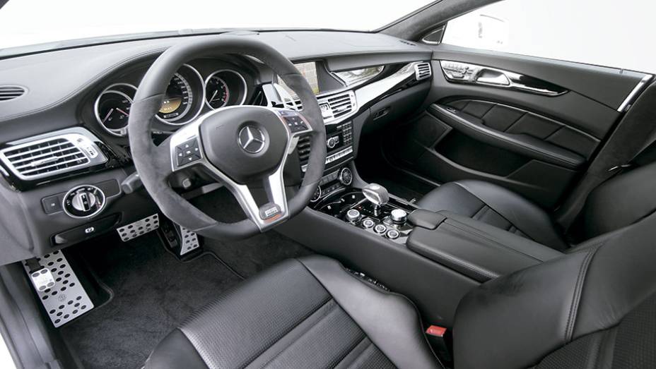 Interior personalizado inclui pedaleiras, volante e grandes borboletas atrás do volante, todos com a marca da empresa | <a href="https://preprod.quatrorodas.abril.com.br/carros/impressoes/brabus-cls-787697.shtml" rel="migration">Leia mais</a>