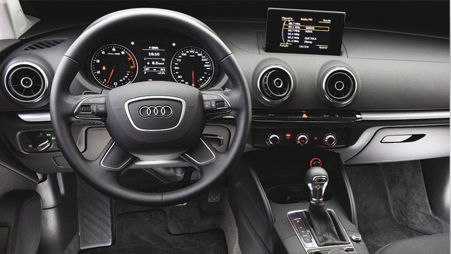 Na cabine, ar-condicionado possui ajuste manual | <a href="https://preprod.quatrorodas.abril.com.br/reportagens/geral/vale-esperar-audi-a3-sedan-nacional-792695.shtml" rel="migration">Leia mais</a>