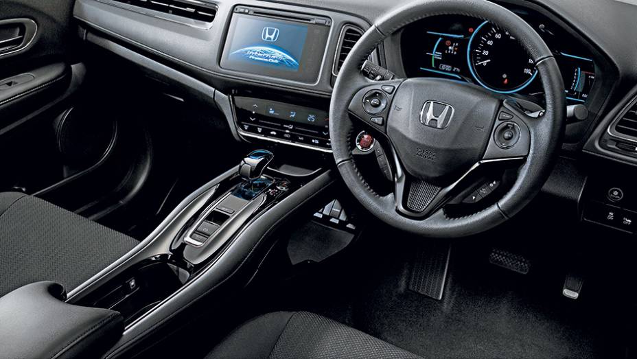 Painel da versão híbrida avaliada no Japão é o mais completo, mas não vem para cá. O console flutuante será mantido | <a href="https://preprod.quatrorodas.abril.com.br/carros/impressoes/honda-hr-v-823521.shtml" target="_blank" rel="migration">Leia mais</a>