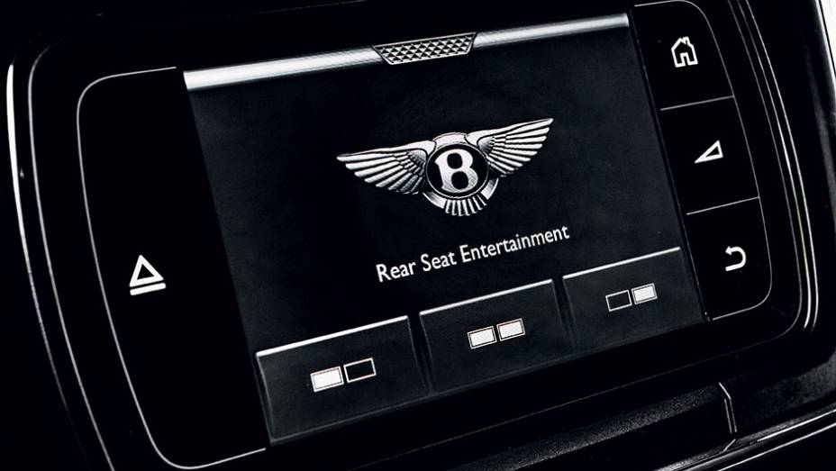 Atr&aacute;s do apoio de cabe&ccedil;a, tela de 10" | <a href="https://preprod.quatrorodas.abril.com.br/carros/impressoes/bentley-flying-spur-840620.shtml" target="_blank" rel="migration">Leia mais</a>