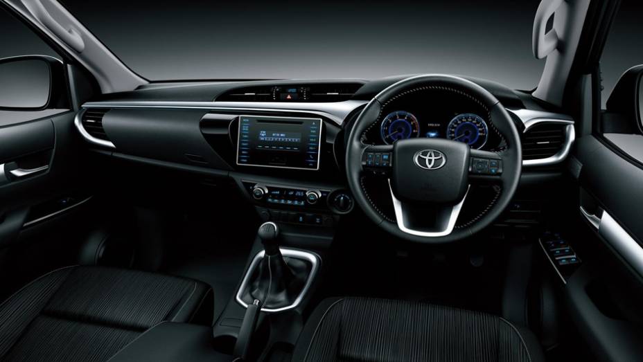 Interior tem conforto de um carro com destaque para a grande tela da central multimídia no painel | <a href="https://preprod.quatrorodas.abril.com.br/noticias/fabricantes/toyota-revela-nova-hilux-2016-867763.shtml" rel="migration">Leia mais</a>