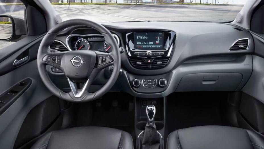 Console central com tela do sistema de entretenimento lembra a do Peugeot 208 | <a href="https://preprod.quatrorodas.abril.com.br/noticias/saloes/genebra-2015/opel-lanca-karl-europa-819122.shtml" rel="migration">Leia mais</a>