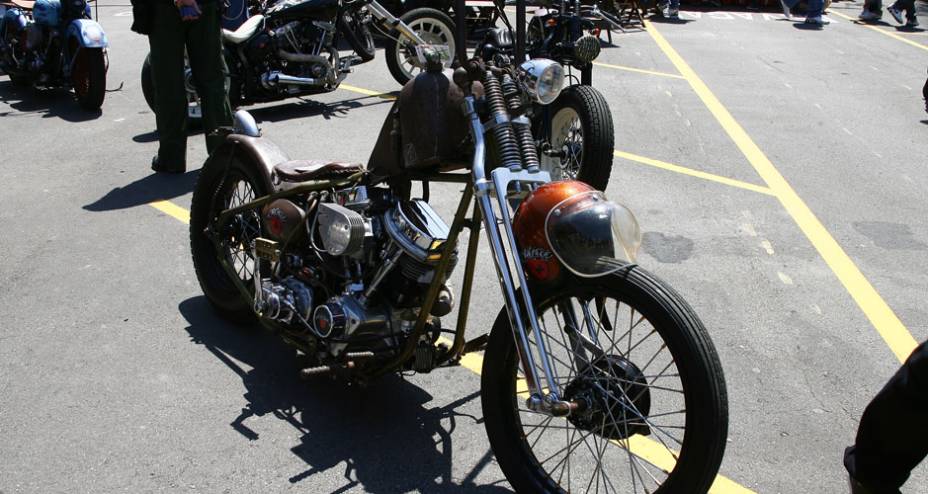 Chopper ao estilo Rat Bike (com aspecto enferrujado) com pedal de partida simulando um de bicicleta, selim fino, rabo duro e motor H-D flathead | <a href="https://preprod.quatrorodas.abril.com.br/moto/noticias/two-wheels-brazil-reune-fabricantes-nacionais-americano" rel="migration"></a>