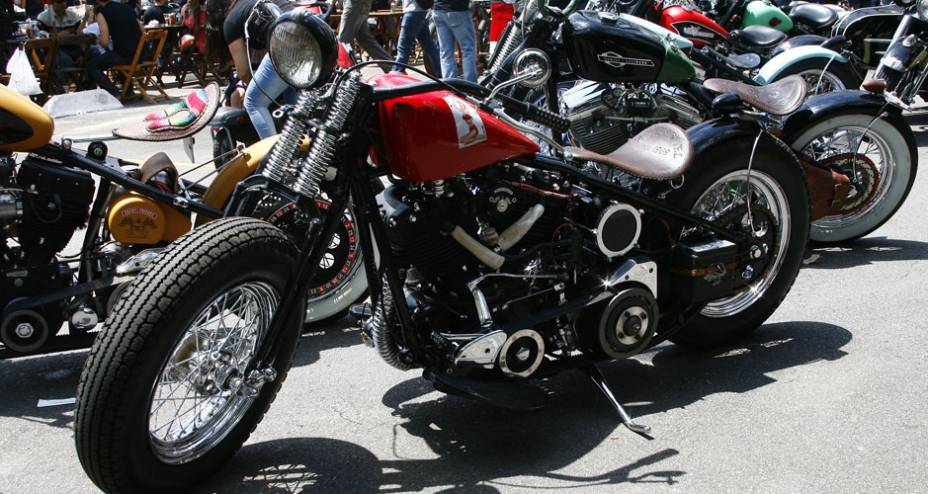 Bobber com frente springer baixa, pneu traseiro adaptado e sem freio frontal, rabo duro, selin fino de couro com molas e motor H-D | <a href="https://preprod.quatrorodas.abril.com.br/moto/noticias/two-wheels-brazil-reune-fabricantes-nacionais-americanos-motos-vinta" rel="migration"></a>