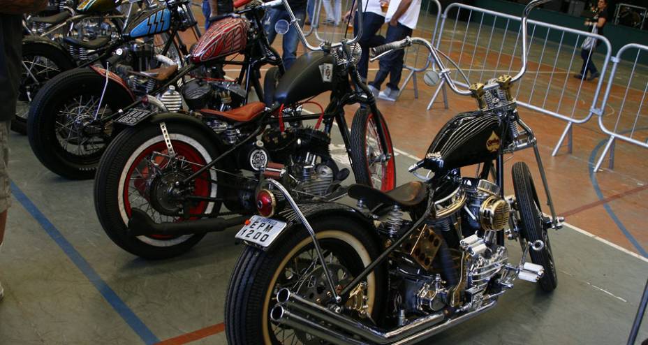 Choppers com frente springer e guid&atilde;o elevado, quadro rabo duro, pneus faixa branca e motores H-D de diferentes gera&ccedil;&otilde;es | <a href="https://preprod.quatrorodas.abril.com.br/moto/noticias/two-wheels-brazil-reune-fabricantes-nacionais-americanos-motos-vintage-644346." rel="migration"></a>