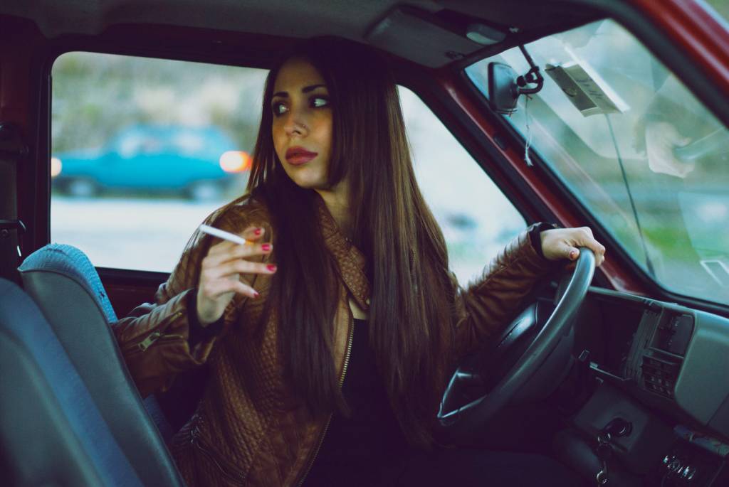 Mulher fumando no volante