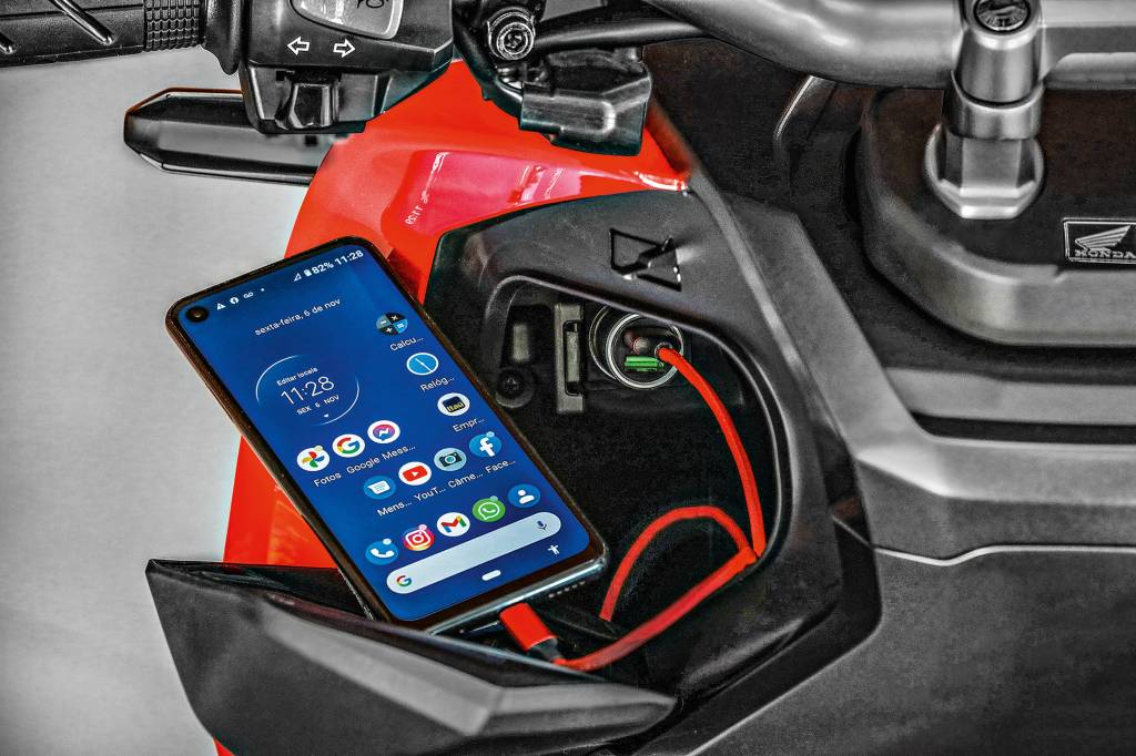 Honda ADV Celular sendo carregado no painel da Honda ADV