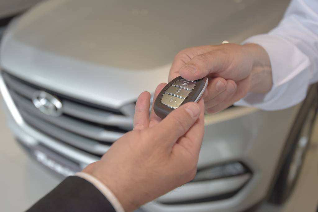 Caoa Seguros Vendedor entrega chave do carro para cliente