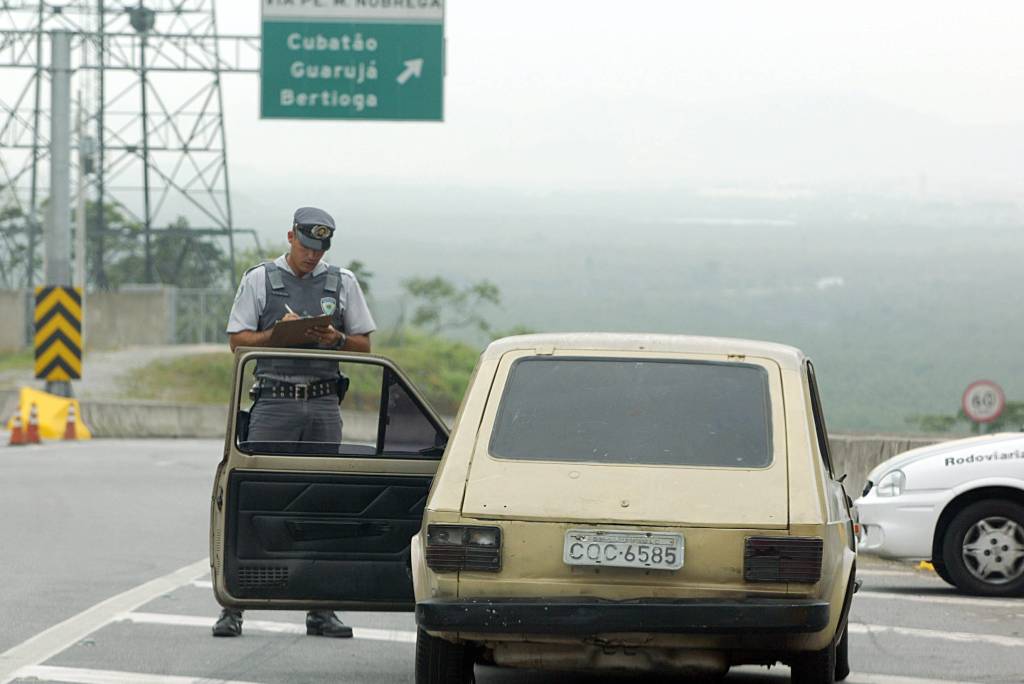 Vagner Beltran, soldado da Polícia Rodoviária autuando o Fiat 147, em péssimo es Vagner Beltran, soldado da Polícia Rodoviária autuando o Fiat 147, em péssimo estado de conservação e com documentação irregular, dirigido por Sérgio Ruiz Luz, editor da revista Quatro Rodas, para elaboração de matéria demonstrando o quanto a fiscalização é ineficaz.