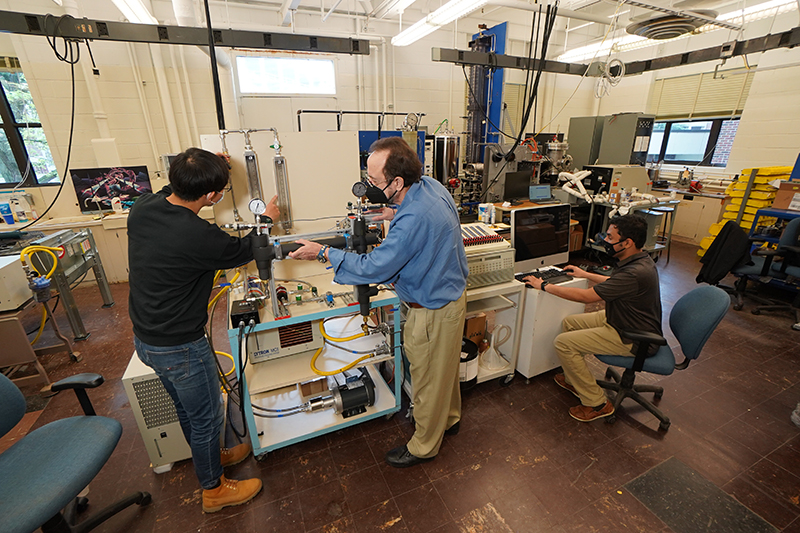 mudawar-cableLO A new charging cable design developed by Purdue professor Issam Mudawar (center) and his students could reduce an electric vehicle’s charging time to under five minutes. (Purdue University photo/Jared Pike)