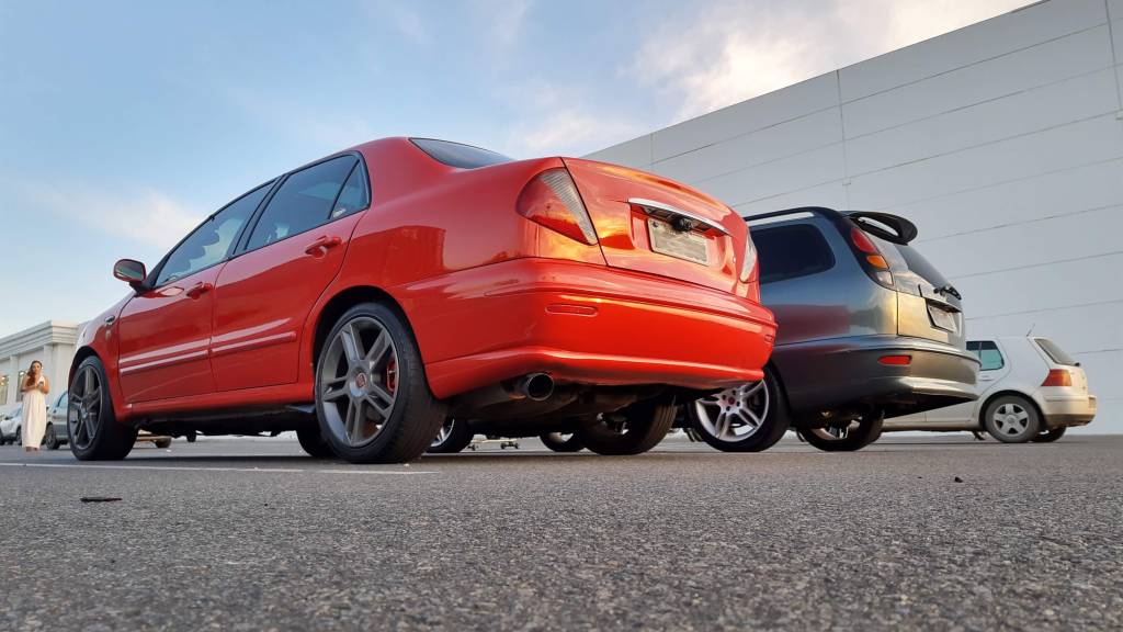 2.4 MARCELLE – MT MARCELLE Marcelle guarda uma dupla de Marea: um sedã vermelho e uma perua Turbo cinza