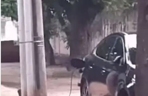 Motorista carrega carro elétrico no poste