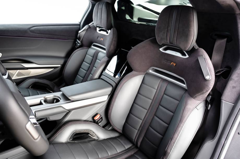 Bancos esportivos ainda preservam algum conforto; há porta-malas dianteiro e traseiro e até botões no teto, como em aviões