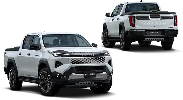 Picape Toyota Hilux branca, vista de frente e traseira, com kit Modellista. A frente tem grade hexagonal e para-choque robusto em preto e cinza. A traseira exibe o nome Toyota em relevo e para-choque preto com detalhes cinzas