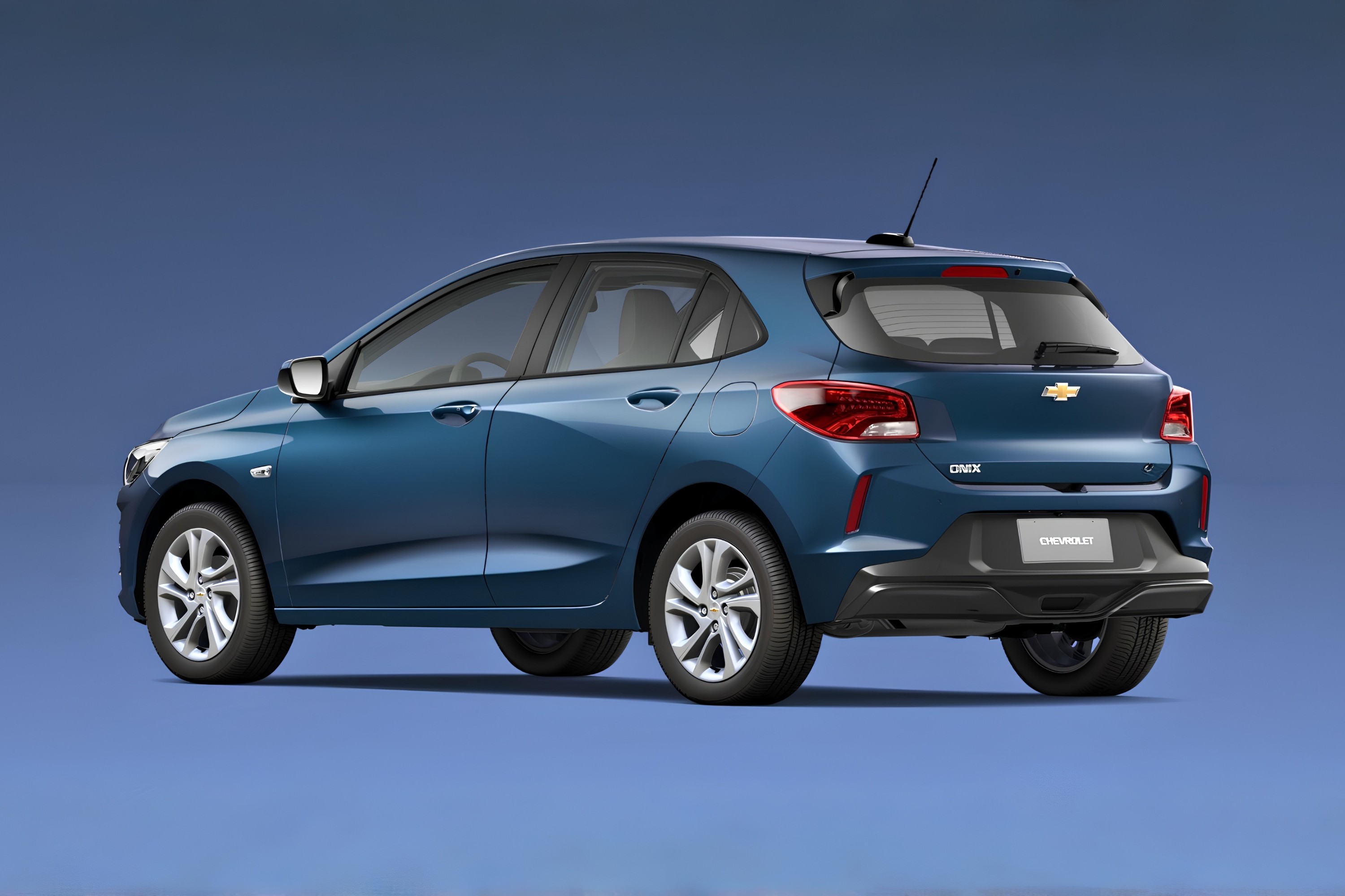Carro Chevrolet Onix azul-escuro, modelo hatch, visto de traseira e lateral direita, com rodas prateadas e detalhes pretos no para-choque, sobre fundo azul liso