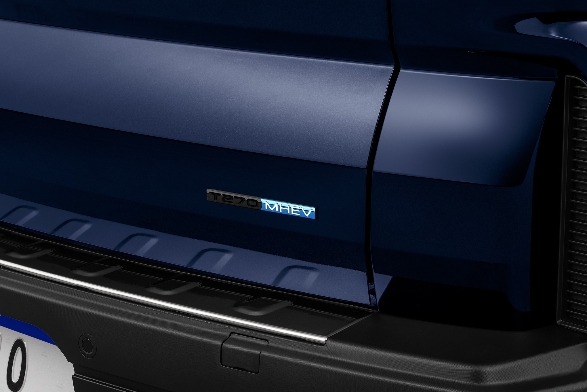 Detalhe da traseira de um carro azul escuro, com o emblema 