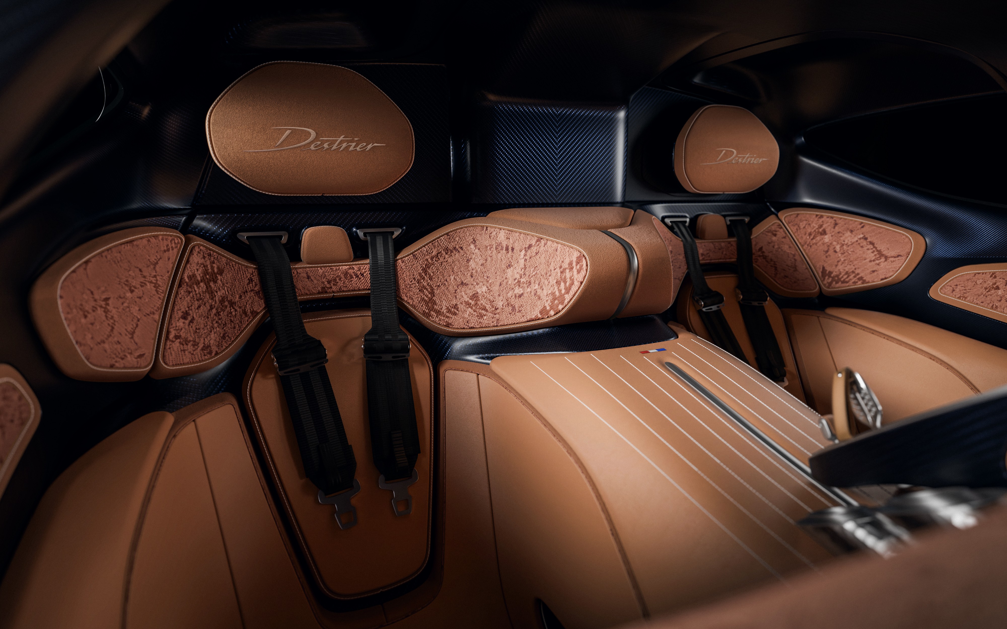 Interior luxuoso de um carro com bancos de couro marrom-claro, detalhes em madeira texturizada e cintos de seguran&ccedil;a pretos. O encosto de cabe&ccedil;a tem a palavra Destrier bordada