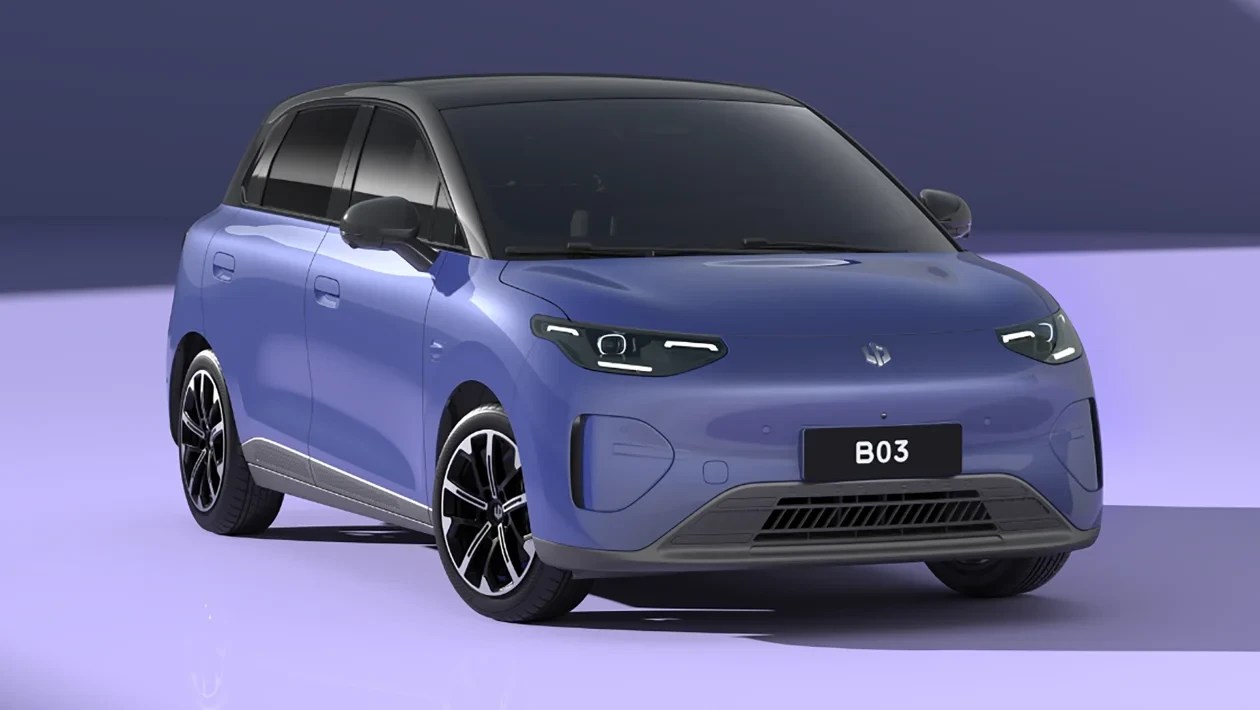 Carro elétrico compacto azul-claro com teto preto, faróis em LED acesos e placa frontal preta com B03 em branco, estacionado em ambiente roxo
